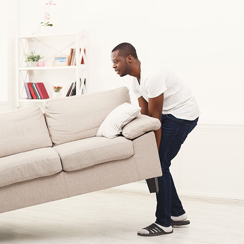 person moving couch for vinyl flooring installation | Luna Flooring Gallery in Chicagoland, Oakbrook Terrace, Deerfield, Kildeer, and Naperville, IL
