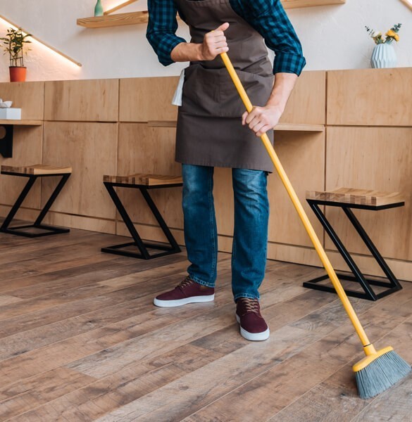 person sweeping hardwood flooring | Luna Flooring Gallery in Chicagoland, Oakbrook Terrace, Deerfield, Kildeer, and Naperville, IL