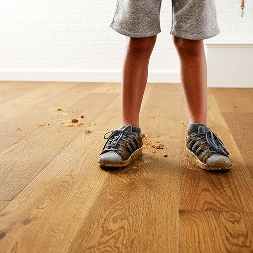 kid's feet with dirt on hardwood flooring, hardwood spills | Luna Flooring Gallery in Chicagoland, Oakbrook Terrace, Deerfield, Kildeer, and Naperville, IL