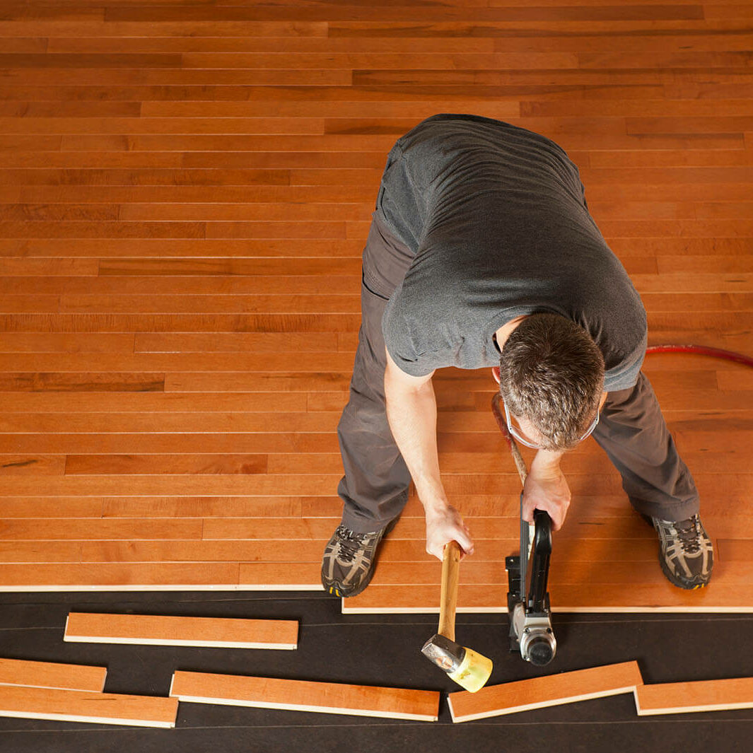 someone installing hardwood planks, during installation | Luna Flooring Gallery in Chicagoland, Oakbrook Terrace, Deerfield, Kildeer, and Naperville, IL